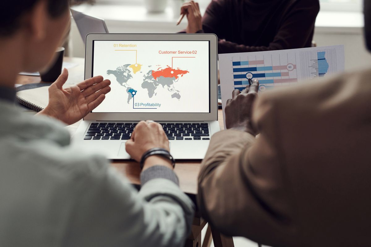 Professional team collaborating around a laptop in a modern office workspace