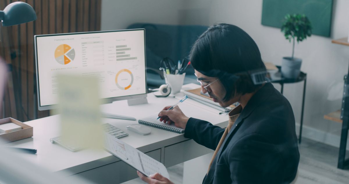 Business professional reviewing charts and analytics at an office desk
