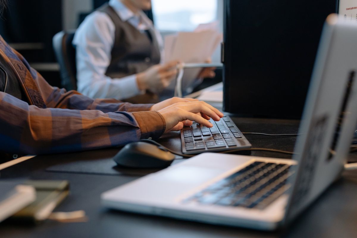 Team members working across computers in a modern office workspace